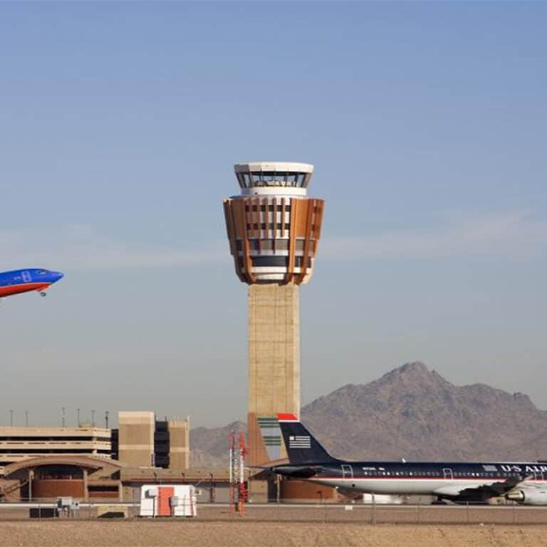 An airplane landing next to the Phoenix Sky Harbor Tower in Arizona