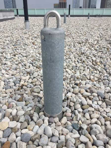 A permanent roof anchor surrounded by decorative stone