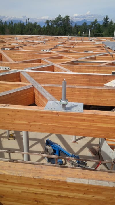 A half-constructed wooden roof with several permanent roof anchors installed