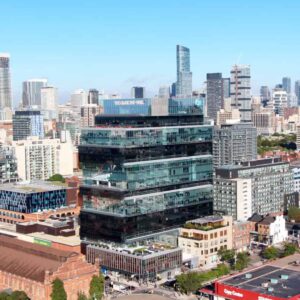 A glass building with every other floor tinted black in the center of downtown Toronto, equipped with window washing davits and permanent roof anchors