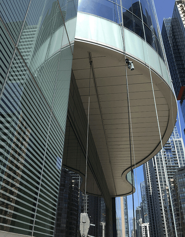 A monorail hoisting system on a white overhang with suspension lines hooked up to it