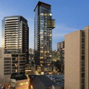 Glass building in Toronto with two uneven elevations, equipped with window washing davits, permanent roof anchors and intermittent stabilization anchors